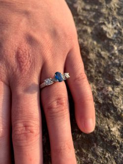 Platinum engagement ring with an oval sapphire and heirloom diamonds set either side