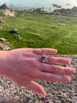 Platinum engagement ring with an oval sapphire and heirloom diamonds set either side