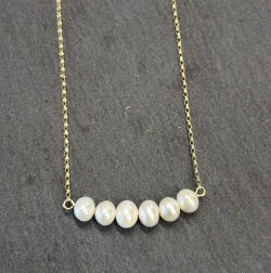 9ct Yellow Gold Necklace with Cultured pearls on slate background