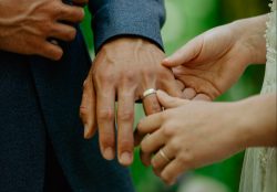 Couple hands with their wedding rings after getting married in the woods